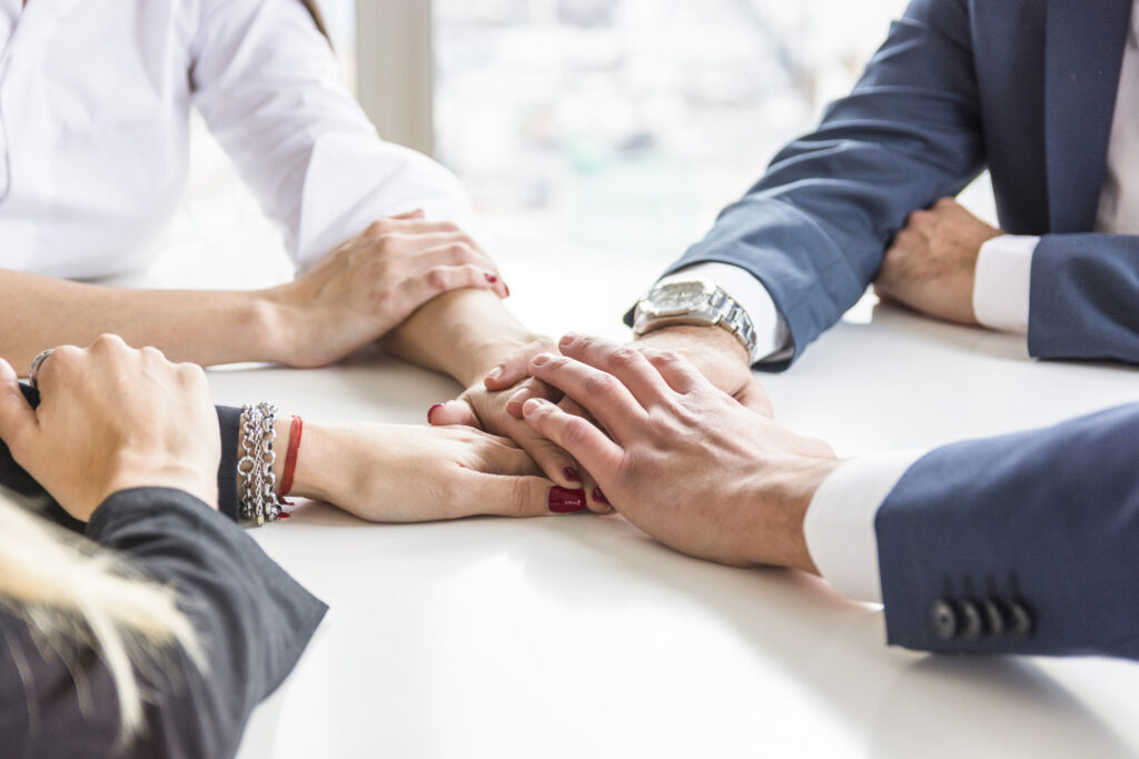 group-businesspeople-stacking-each-other-s-hand-white-desk (1)